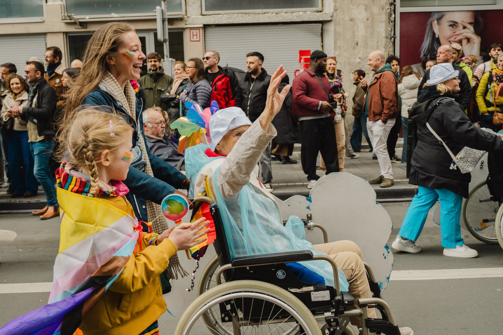 Pride parade with diverse participants celebrating, including a woman in a wheelchair