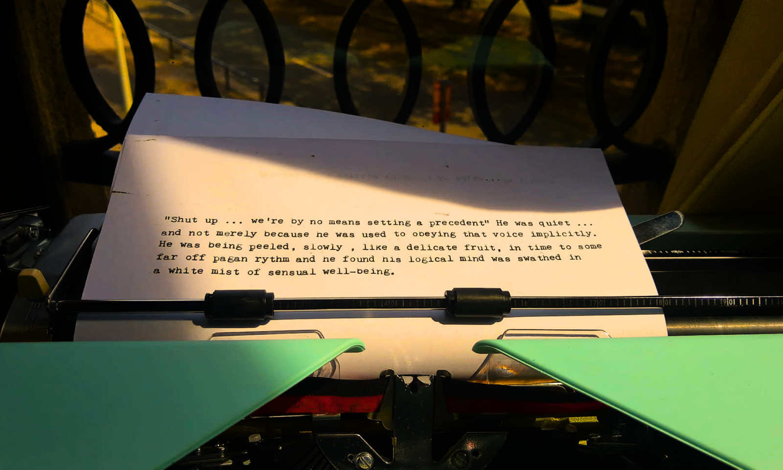 Een appelblauwzeegroen typemachine in een warm licht bevat een papier waarop een romantische scène staat beschreven tussen kapitein Kirk en Spock van Star Trek.