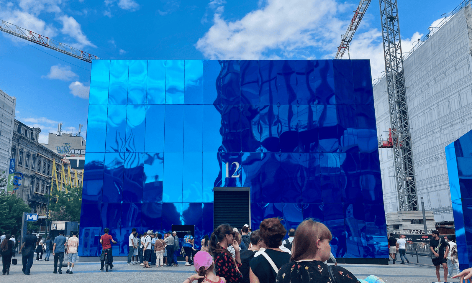 Een rechthoekig gebouw gemaakt uit spiegels in een blauwe kleur met de letter 12 op.